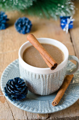 A cup of coffee on a wooden table with Christmas decorations