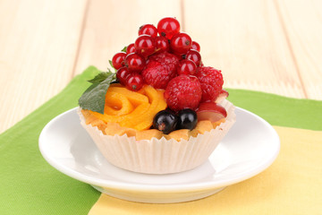 Dulcet cake with fruit and berries on wooden table