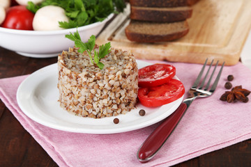 Buckwheat in plate with bread and vegetables closeup
