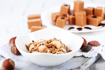 Many toffee on plate and in bowl on napkin on board close-up