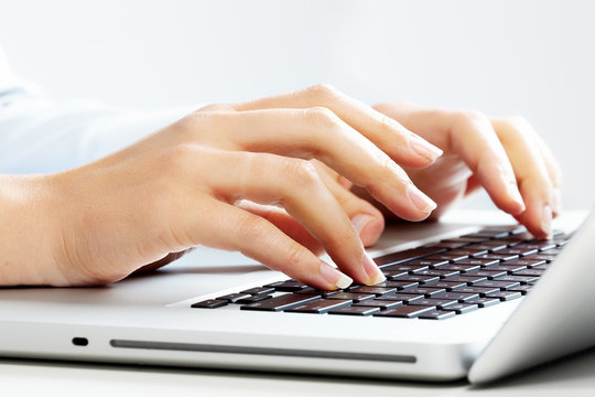 Hands with laptop computer keyboard.