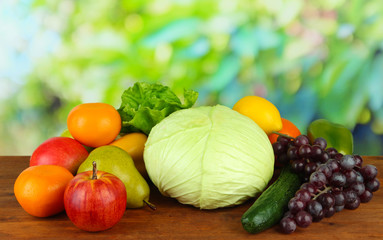 Different fruits and vegetables on table on wooden background