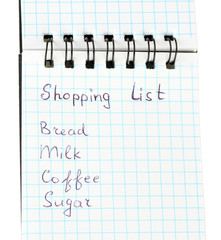 shopping list in a notebook on white background close-up