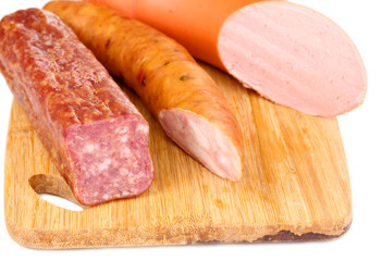 Tasty sausage on chopping board close-up
