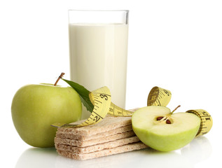Glass of kefir, green apples, crispbreads and measuring tape