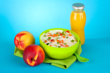 tasty dieting food and bottle of juice, on blue background