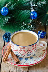 A cup of coffee on a wooden table with Christmas decorations