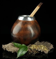 Calabash and bombilla with yerba mate isolated on black