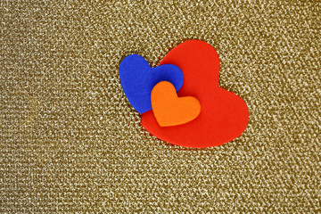 Hearts made of felt on golden background