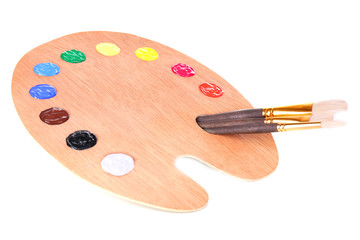 Wooden art palette with paint and brushes isolated on white
