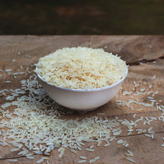 Rice with white cup on wooden table.
