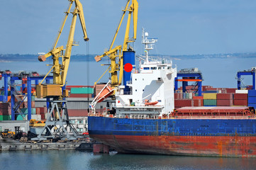 Fototapeta premium Bulk cargo ship under port crane bridge, Odessa, Ukraine