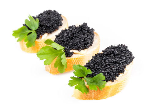 Three small sandwiches with black caviar