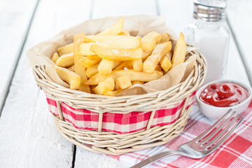 French fries in wicker basket on white table - bar menu