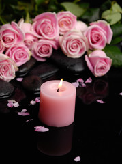 Fototapeta na wymiar Pink branch rose with black stones and candle