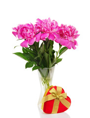 Three big pink peonies in glass vase