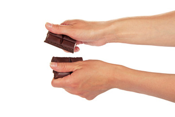 Female hands break a tile of black chocolate