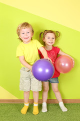 Fototapeta na wymiar Smiling boy and girl with bright balls