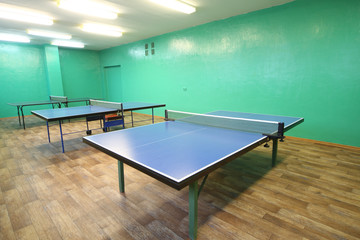 Three blue ping pong tables in the room