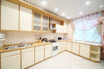 Fototapeta na wymiar Interior of modern kitchen with beige furniture