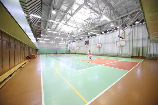 Two women playing tennis in the indoor tennis court
