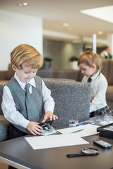 Little boy and girl in business suit playing in business center