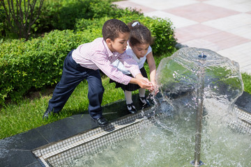 Brother and sister draw water from the fountain