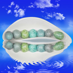 Bunte Ostereier in Dekoschale mit Wasserspiegelungen