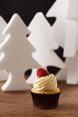 Raspberry and butter cream cupcake on Christmas background