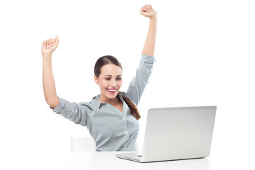 Woman in front of laptop with arms raised