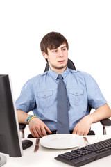 Young businessman sitting in front of empty plate in the office