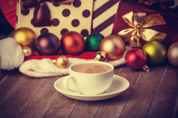 Cup of coffee and gifts at background
