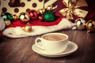 Cup of coffee and gifts at background