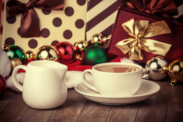 Cup of coffee and gifts at background