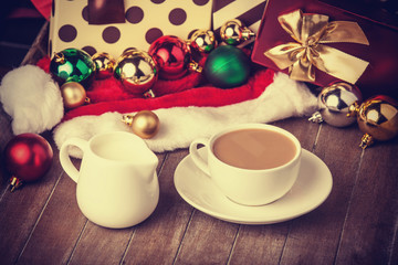 Cup of coffee and gifts at background