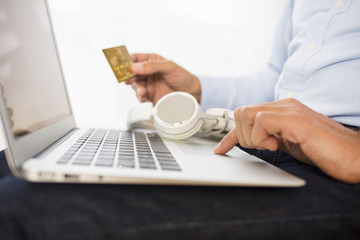 Man buys music on-line on computer with credit card, e-commerce