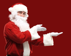 Santa Claus with his arms out in a presenting gesture