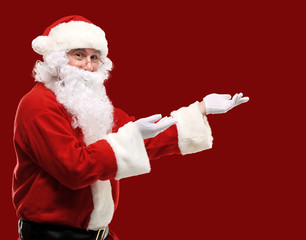 Fototapeta na wymiar Santa Claus with his arms out in a presenting gesture