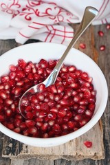 Pomegranate in the retro bowl on a wooden background