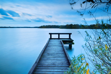 Naklejka premium wooden pier on big lake with long exposure