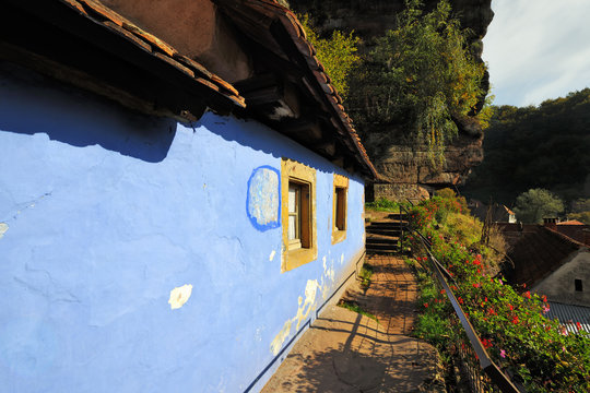 Blue troglodyte house in rock face at Graufthal, Alsace