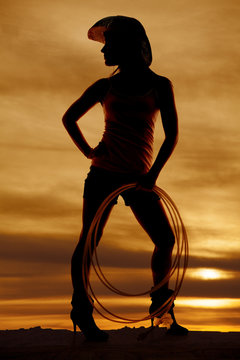 silhouette woman cowgirl holding rope look side