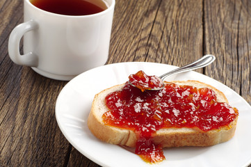 Piece of bread with jam and tea