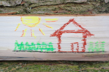 Dom narysowany na kawałku drewna