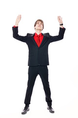 Young businessman in suit standing with hands over head