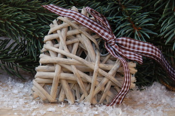 Herz mit Schleife und Tannengrün im Schnee