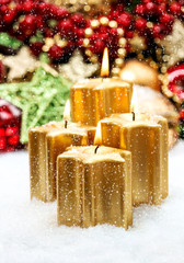 advent decoration with four burning candles and falling snow
