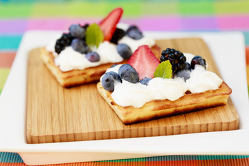 Waffles and fresh seasonal fruits, whipped cream