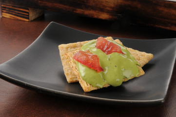 Guacamole and tomato on cracker