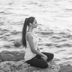 girl in lotus pose at sunset